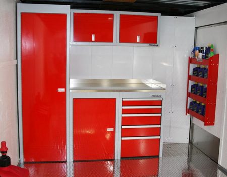 Red Sportsman II series cabinets with workbench on back wall of trailer