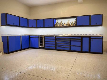 Custom blue cabinets with black anodized frames installed in garage with stem wall